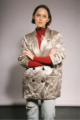 Blazer oversize plateado con leve relieve, solapas clásicas, cuatro botones, hombros marcados y forro interior.