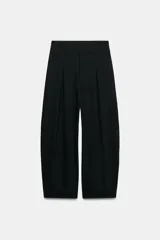 Pantalón balloon de tiro alto color negro con pliegues en el delantero y bolsillos laterales ocultos en la costura.