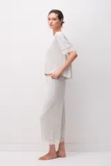 Pijama de modal jersey color gris claro melange, compuesto por una remera de manga corta con detalles de encaje en las terminaciones y un pantalón largo a juego con encaje en el ruedo.