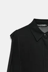 Camisa negra fluida de manga larga, cuello solapa y cierre frontal oculto con botones.