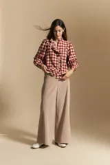Camisa de algodón a cuadros con diseño de volados frontales, cuello alto y mangas largas con leve volumen.