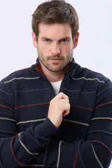 Buzo de algodón tejido color azul marino con rayas horizontales en beige y bordó. Presenta cuello alto con medio cierre frontal y puños y dobladillo acanalados.