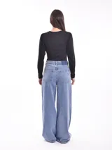 Remera negra de manga larga con cuello redondo y detalle de pequeñas tachas plateadas alrededor del cuello.