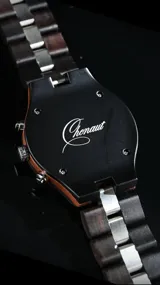 Reloj cronógrafo de la colección Imperial, con caja de madera de ébano oscuro y bisel técnico. La esfera negra presenta subdiales con textura de madera natural, indicador de fase lunar y fechador. La malla combina eslabones de acero inoxidable pulido con madera de ébano, ofreciendo un diseño sofisticado y resistente.