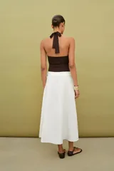 Body de cuello halter con espalda descubierta, confeccionado en poliamida. Presenta un diseño drapeado en los laterales y una abertura frontal con detalle metálico. Posee cierre con botones a presión en la parte inferior y lazada en el cuello.