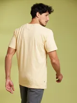 Remera de manga corta color arena, con cuello redondo y un bolsillo de parche en el pecho.