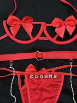 Conjunto de lencería rojo compuesto por soutienne con aros y moños decorativos, bombacha vedetina con letras de strass y tiras regulables, y portaligas con arnés y cadenas de brillantes.