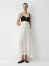 Vestido midi con breteles finos, cuerpo superior negro y falda blanca.