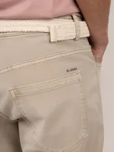 Pantalón de gabardina de corte slim fit y tiro medio, con diseño de cinco bolsillos y cierre de cremallera.