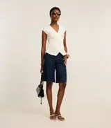 Bermuda femenina modelo jorts, confeccionada en raw jeans, con cintura alta y cintura sastre. Posee bolsillos tradicionales y cierre delantero con botón y cremallera. Este producto posee algodón de certificado BCI en su composición, siendo ambientalmente más sostenible.