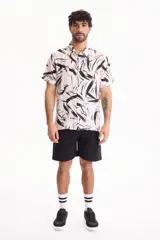 Camisa de viscosa de manga corta con corte clásico, fondo blanco y estampado abstracto en color negro.