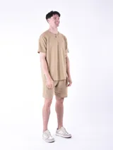 Remera blanca a rayas horizontales grises, con cuello redondo abotonado y bolsillo en el pecho.