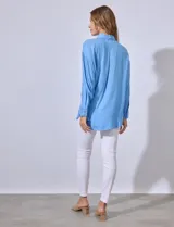 Camisa amarilla con bordado floral, cuello con solapa, abertura central con botones y bolsillo aplicado en el pecho.