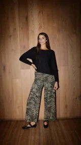 Pantalón palazzo de punto fino, tiro alto, con estampado botánico en tonos verde oliva y negro.