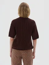 Buzo tejido de manga corta color rojo, con cuello redondo y diseño de punto acanalado y trenzado.