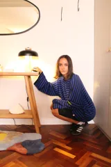 Sweater oversize de punto con diseño a rayas horizontales en color verde y blanco, cuello redondo en contraste rojo y detalle de etiqueta bordada en la manga.