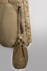 Campera puffer color beige con cuello alto, cierre frontal con cremallera y bolsillos laterales con cierre. Diseño acolchado horizontal.