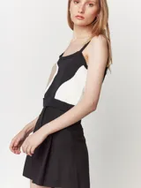 Short color beige de lino con tiro alto, elástico en la pretina trasera, cierre delantero con botón, tablas en el frente, bolsillos delanteros y dobladillo invisible.