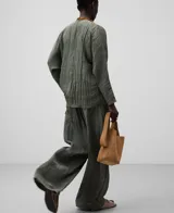 Blusa verde oliva de tejido arrugado con poliéster reciclado. Escote pico, manga japonesa, delantero cruzado y ata lateralmente con tira estrecha del mismo tejido.