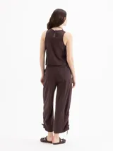Top de twill color beige, de silueta recta y diseño sin mangas con cuello redondo. Se destaca por sus aberturas laterales con lazos regulables y remaches metálicos.