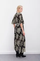 Vestido largo de viscosa con jacquard de flores en lurex dorado. Presenta escote en V cruzado, mangas al codo y elástico en la cintura con lazo ajustable. Incluye un viso al tono con breteles regulables.