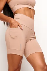 Short tipo biker de tiro alto, diseñado para running y entrenamiento. Confeccionado en tejido técnico de alta performance con bolsillos laterales funcionales y bolsillo interno en la cintura. Presenta detalles reflectivos y costuras estratégicas para mayor libertad de movimiento.