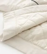 Campera bomber de microfibra color beige con estampado frontal de lettering 'PARIS 1985'. Presenta cierre frontal con cremallera, cuello alto, bolsillos funcionales y puños y ruedo ajustados con elástico.