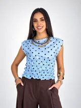 Blusa sin mangas de viscosa color negro con estampado de lunares blancos, cuello redondo y cintura fruncida con elástico.