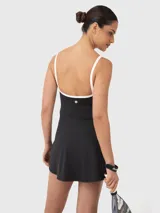 Vestido deportivo negro con breteles finos en color blanco, diseñado para padel o tenis. Incluye calza corta separada para mayor comodidad durante el juego.