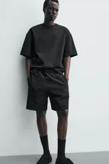 Bermuda estilo jogger de ajuste relajado, color negro, confeccionada en tejido interlock de algodón. Cuenta con cintura elástica ajustable mediante cordón, bolsillos delanteros tipo vivo y diseño liso.