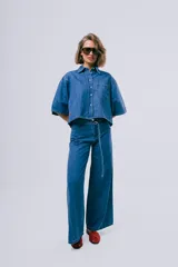 Pantalón de jean estilo wide leg, color azul, de tiro alto con pasa cinto y cinturón fino incorporado.