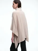 Poncho amplio de cuello alto, confeccionado en hilado con lana y cashmere, con diseño de caída recta y botones laterales.