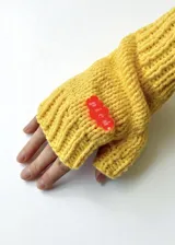 Mitones tejidos a mano con lana poliéster color amarillo y detalle de aplique acrílico rojo.