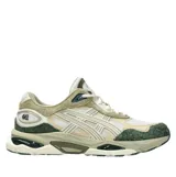 Championes Asics modelo Gel-Nyc 2.0, con diseño robusto y combinación de tonos blanco, beige, verde oscuro y detalles en gris. Incorporan tecnología GEL en la suela y una mezcla de texturas de malla y gamuza.