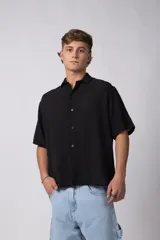 Camisa de manga corta confeccionada en lino, con cuello clásico y cierre frontal de botones. Presenta un corte relajado y textura liviana.