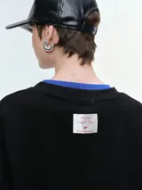 Buzo de cuello redondo y manga larga, con diseño oversize y corte relajado. Presenta puños y ruedo acanalados, confeccionado en tejido de textura suave.