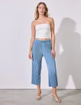 Pantalón capri negro de satén plisado con pretina ancha elastizada.