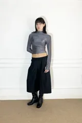 Polera gris de lycra con cuello alto y mangas largas.