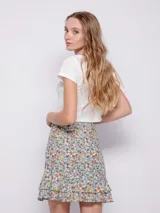 Minifalda verde con estampado de flores blancas y volados en el ruedo.