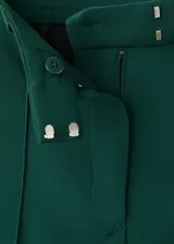 Pantalón de vestir tiro medio color verde oscuro, de corte recto y largo, con trabillas para cinturón y cierre oculto.