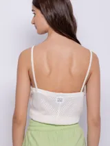 Top sin mangas de tela texturada color verde lima, con tirantes finos y escote cuadrado con detalle de terminación festoneada.