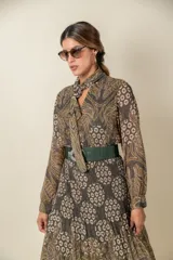 Cinto de cuero color beige con elástico y hebilla ovalada metálica plateada.