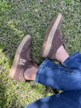 Championes de gamuza color borgoña, beige y naranja con cordones.