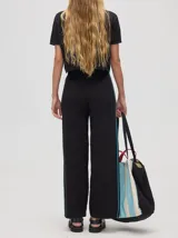 Pantalón de tiro alto, corte holgado y pierna ancha, confeccionado en algodón color beige. Presenta una franja lateral en contraste y cintura elástica con cordón ajustable.