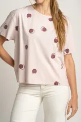 Remera rosa de algodón con estampado de lunares marrones.