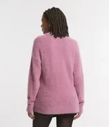 Suéter de punto con textura peluda, cuello redondo y manga larga. Presenta un diseño de corte holgado y acabado suave.
