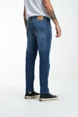 Jean de calce recto, color azul medio, con bolsillos delanteros y traseros.