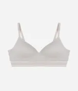 Soutien tipo bralette de color blanco hueso, sin costuras (seamless), con copas moldeadas y escote en V. Presenta una banda ancha elástica bajo el busto para mayor soporte y tirantes finos ajustables.