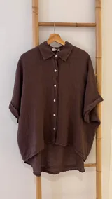 Camisa verde militar de lino italiana con botones de nácar, corte holgado, cuello camisero y mangas cortas con dobladillo.