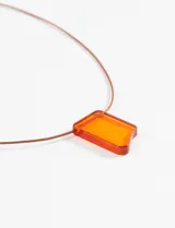 Gargantilla de cordón marrón con dije rectangular de acrílico naranja translúcido y cierre metálico regulable.